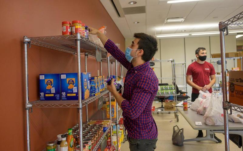 A student stocks pantry shelves