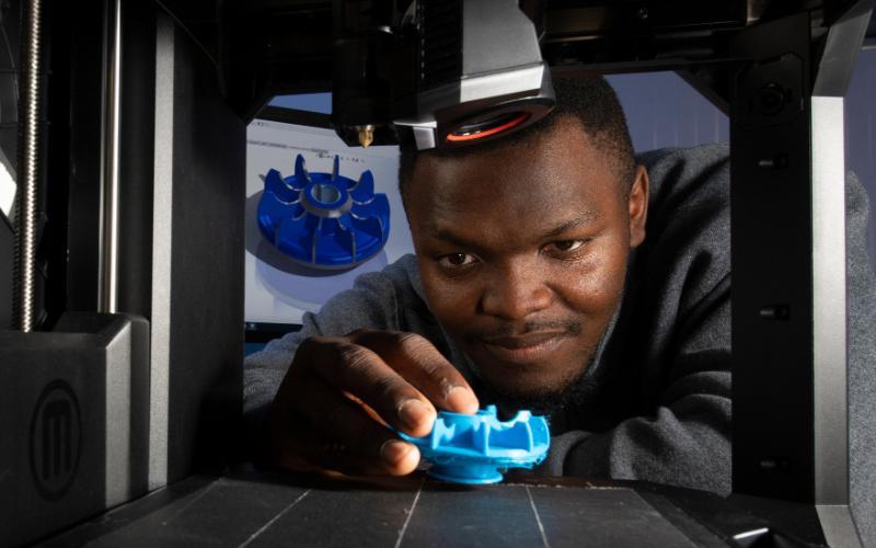 A student uses a 3D printer to bring CAD piece to life.