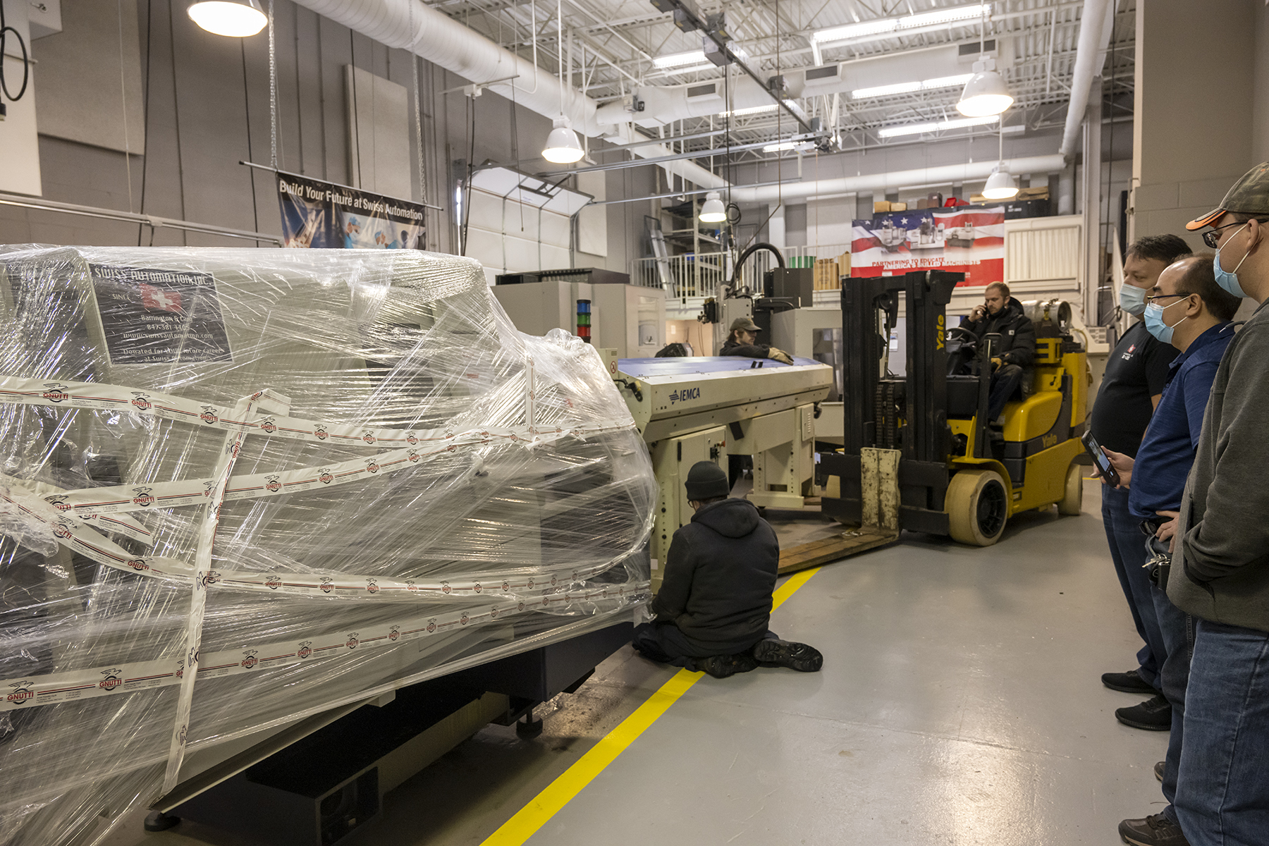 Swiss Automation machine techs install the 9-axis CNC machine in ECC