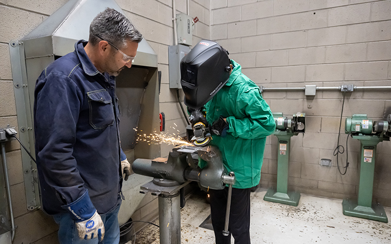 An ECC instructor assists a participant at the 2024 summer manufacturing camp