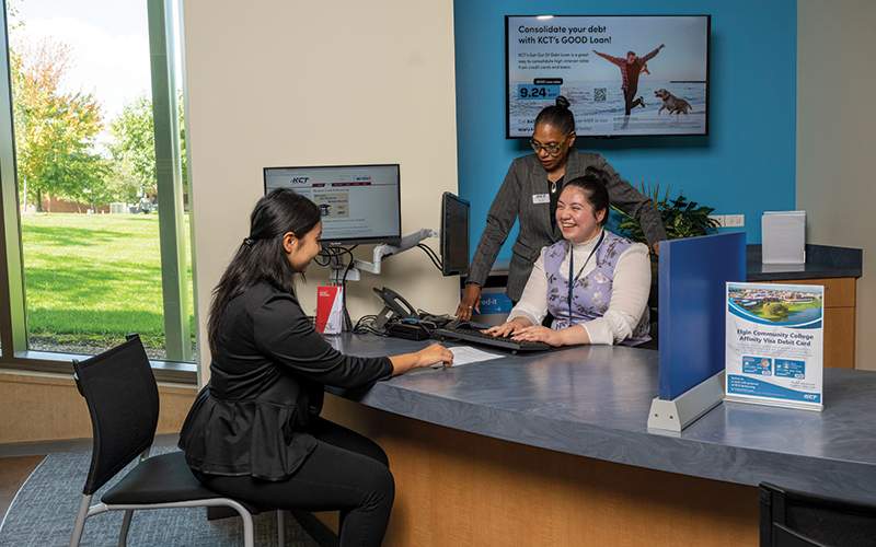 Two representatives from the Kane County Teachers (KCT) Credit Union assist a student at the Center for Financial Empowerment and Wellness