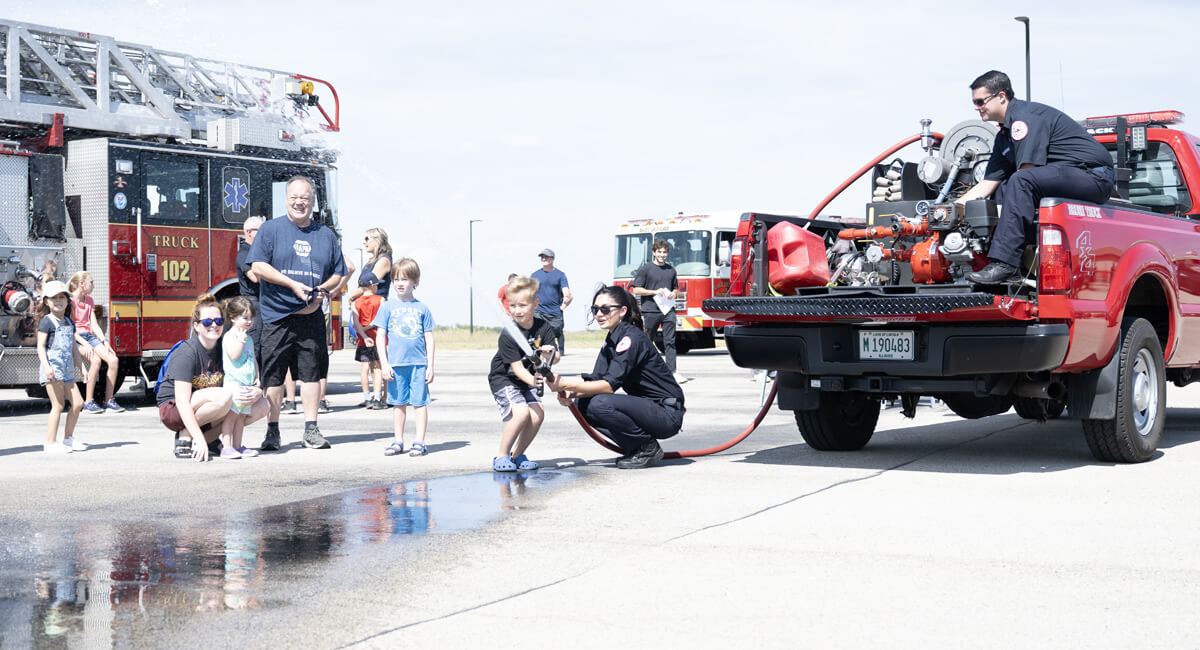 Fire personal demonstrating how to work a fire hose at a touch a truck event.