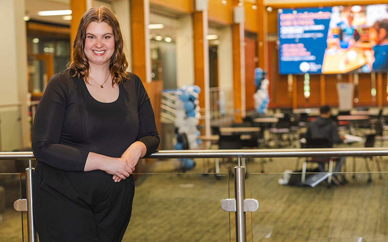 A student stands in the Jobe Lounge