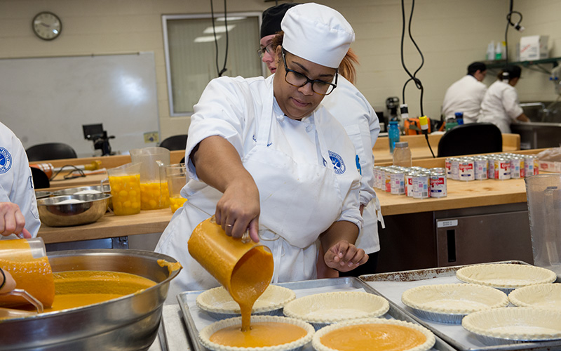 Culinary student making pumpkin pies