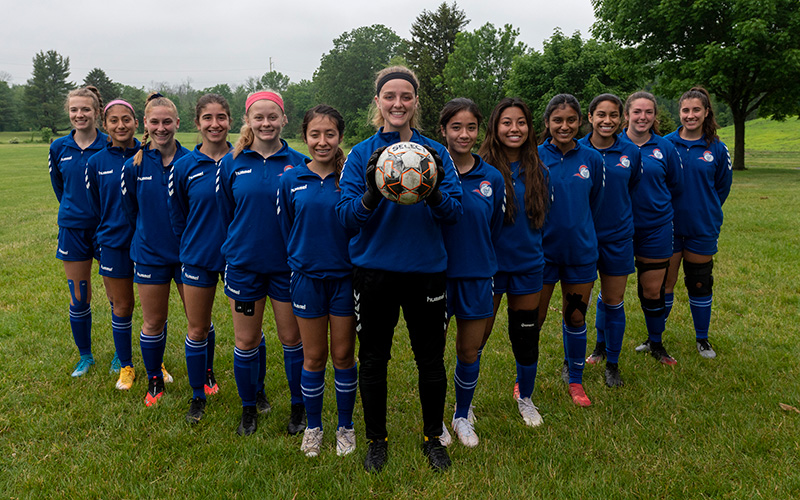 ecc women's team lined up with the team captain holding a soccer ball