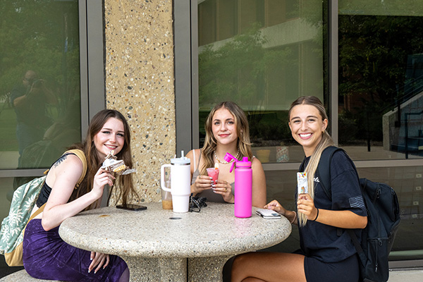 three students siting around a table