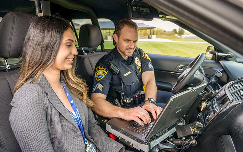 Student in a car with police officer