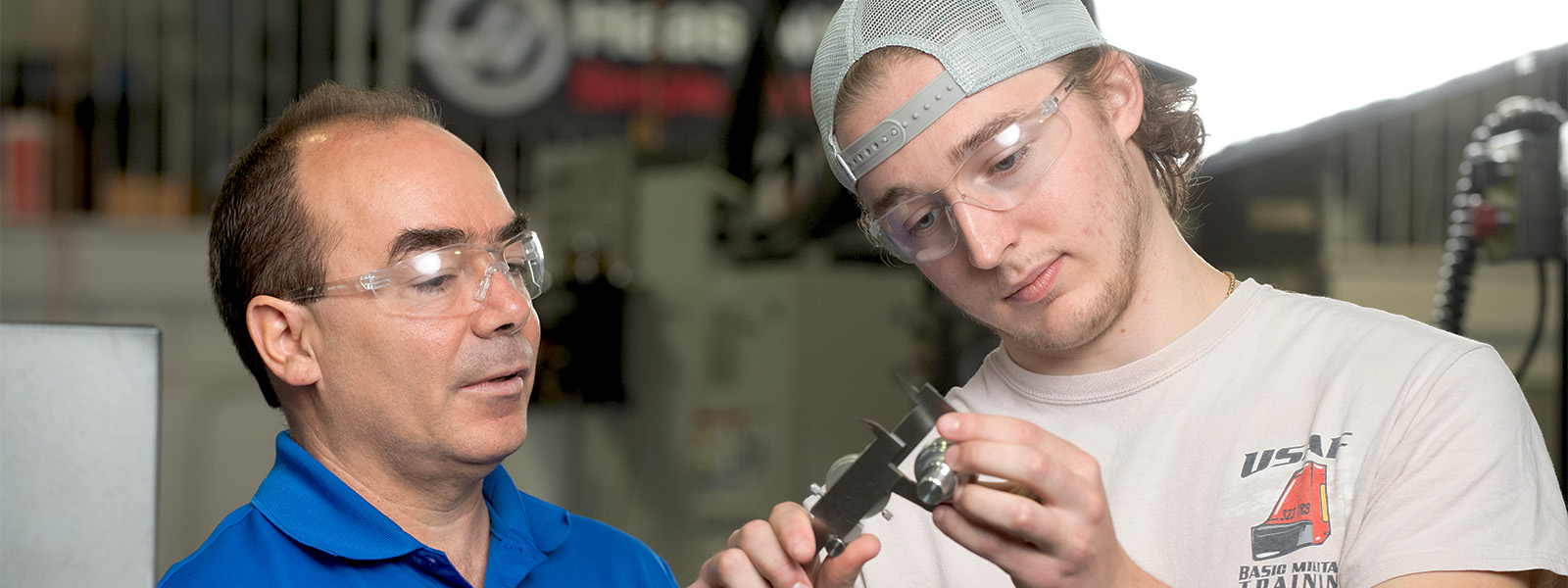 Student working with instructor manufacturing program