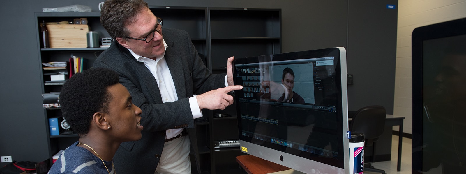 Communication design student in videography class with instructor.