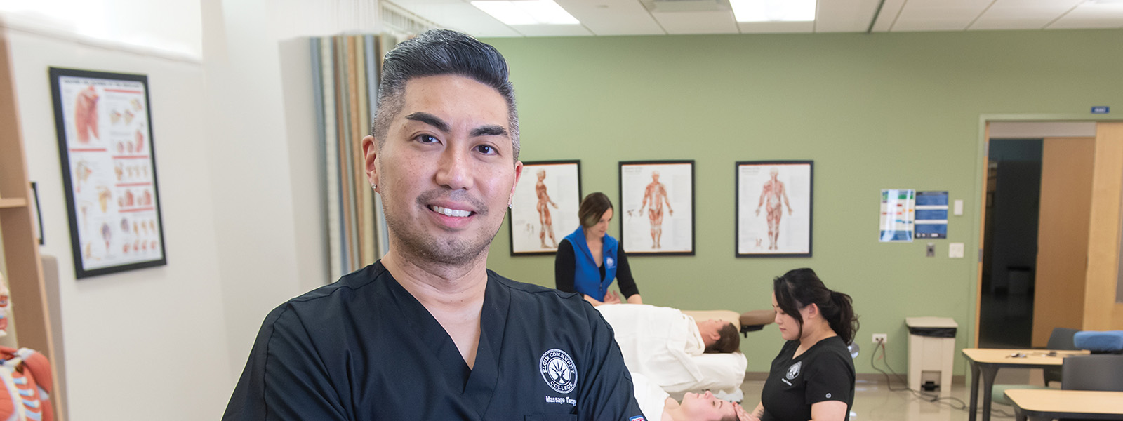 Student standing in massage therapy classroom