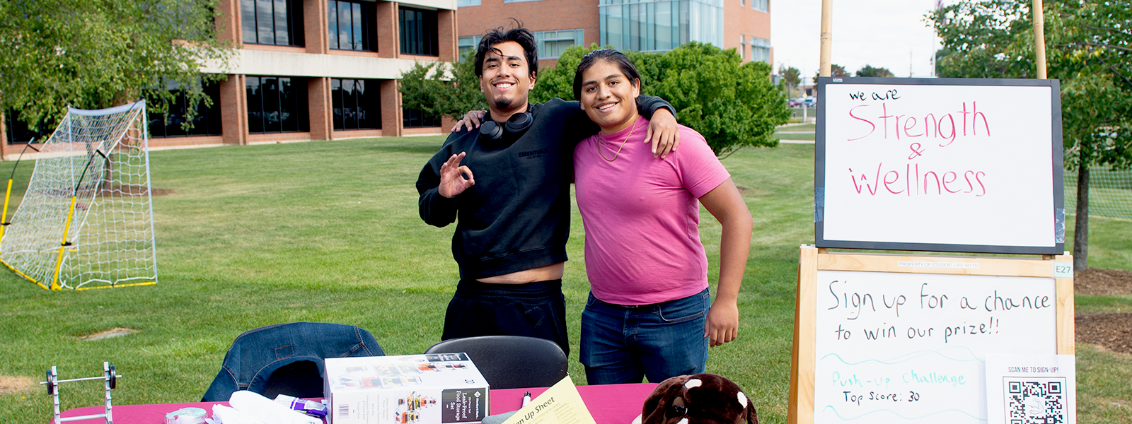 Two strength and wellness members with their arms around each other.